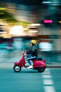 Persoon rijdt op een moderne elektrische scooter als milieuvriendelijk transportmiddel in de stad